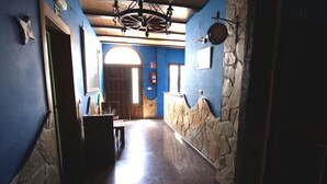 A narrow hallway with stone walls and a wooden door at the end. - El Rincón de Piedra Apartamentos Rurales (Enguidanos)