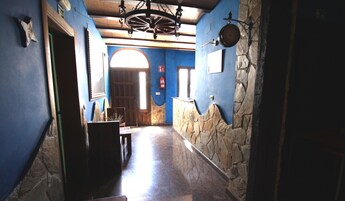 A narrow hallway with stone walls and a wooden door at the end.