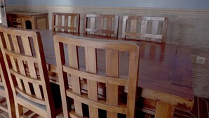 A dining area with wooden chairs and a table. - El Rincón de Piedra Apartamentos Rurales (Enguidanos)