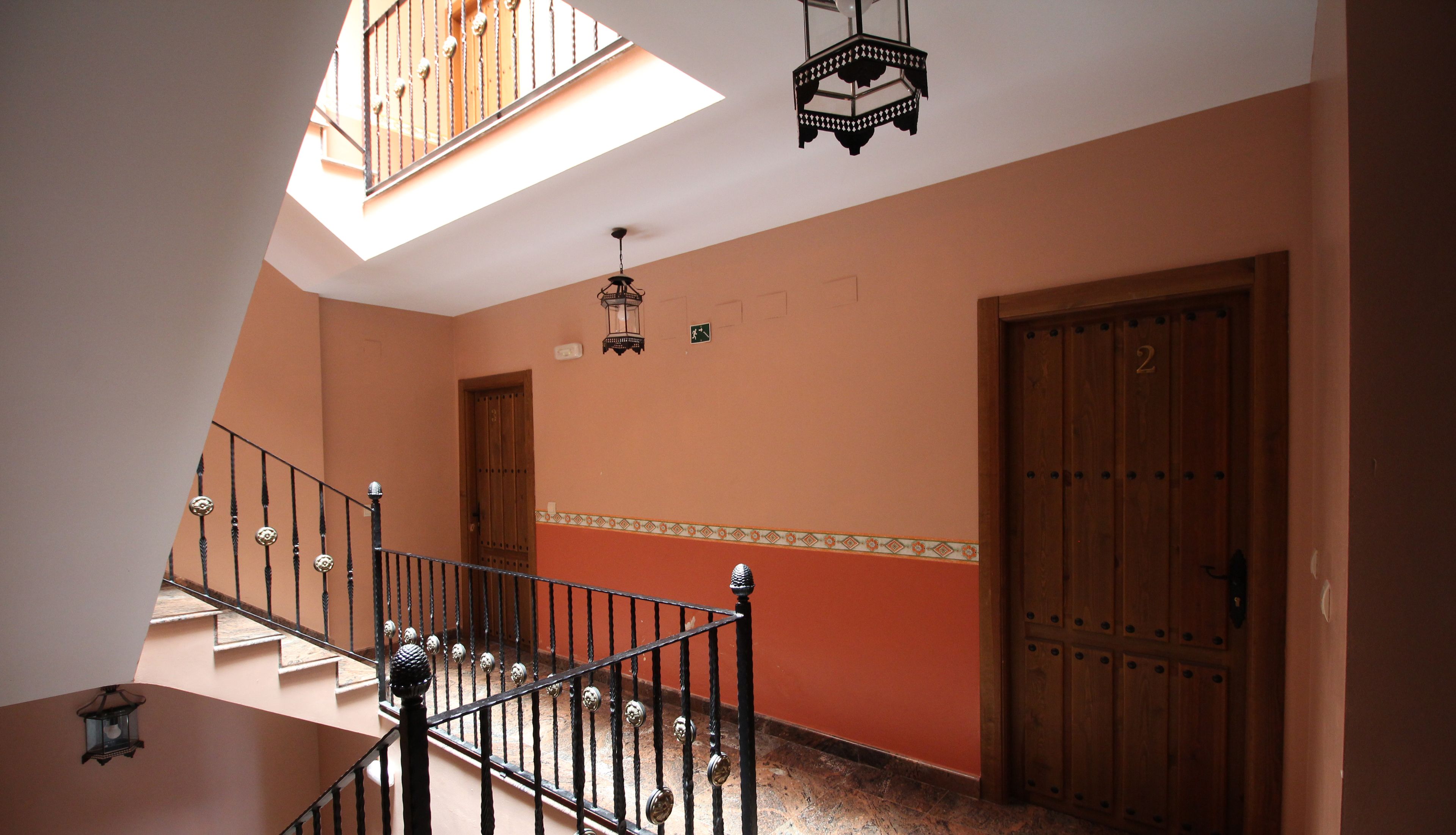 A staircase with a metal railing, a wooden door, and a wall with a decorative border.