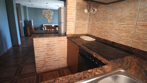 A kitchen with a granite countertop, a stainless steel sink, and a built-in stove. - El Rincón de Piedra Apartamentos Rurales (Enguidanos)