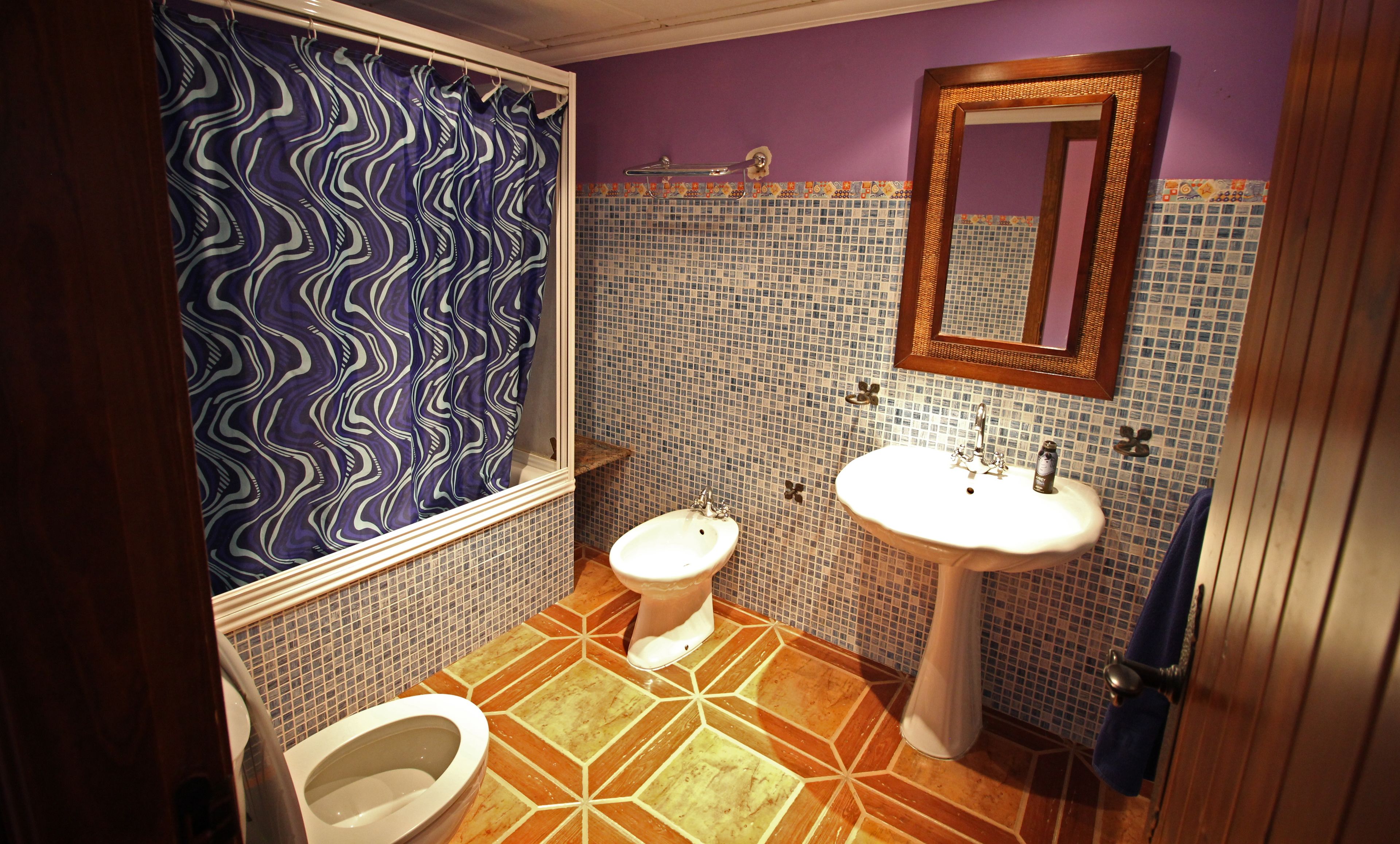 Un baño con inodoro, lavabo y cortina de ducha.
