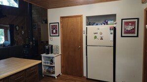 Eine Küche mit Holzausstattung, einem weißen Kühlschrank und einer Holz Arbeitsplatte.