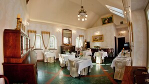 A dining area with multiple tables set for service, a large mirror, and a chandelier. - Willa Różana - Ormonde Resorts (Naleczow)