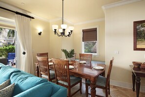 A dining area with a wooden table, chairs, and a chandelier.