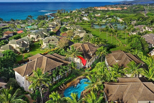 A residential area with houses, a swimming pool, and a view of the ocean.