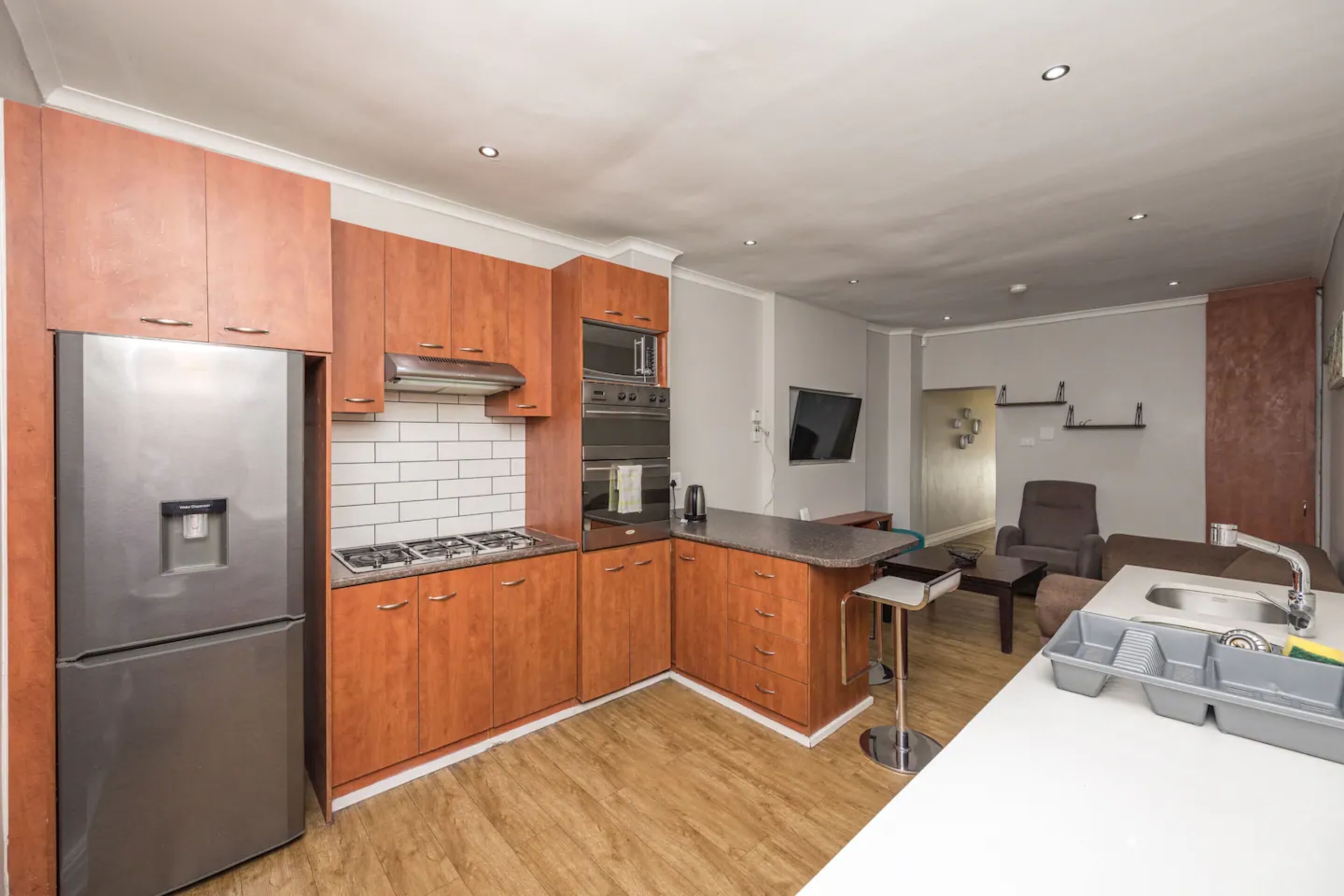 A modern kitchen with wooden cabinets, stainless steel appliances, and a built-in oven.