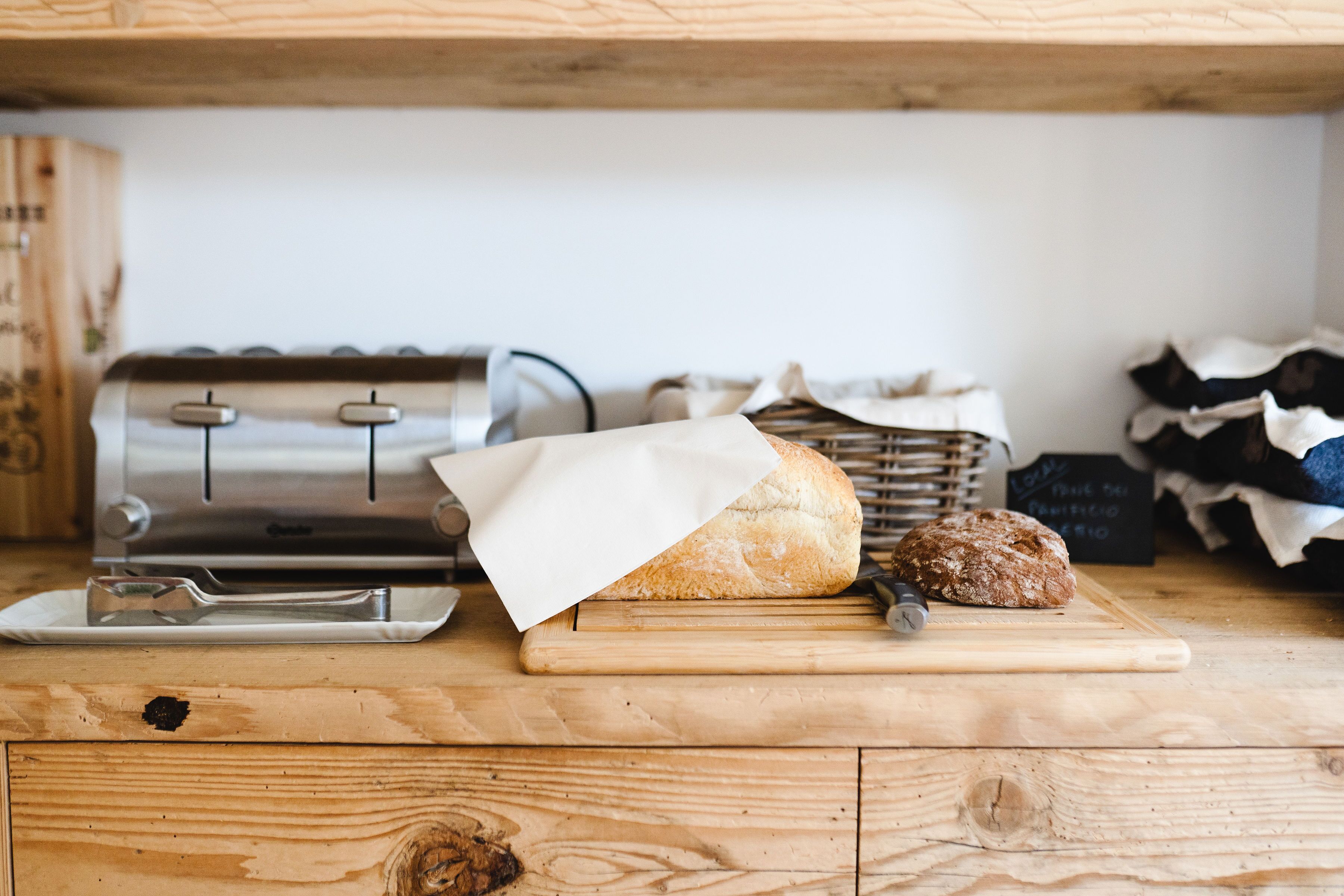 Eine Holz Arbeitsplatte mit einem Brotlaib und einem Brot Schneidgerät.
