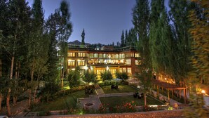 Un hôtel à plusieurs étages doté d’un jardin bien éclairé et d’un espace extérieur aménagé avec des sièges.