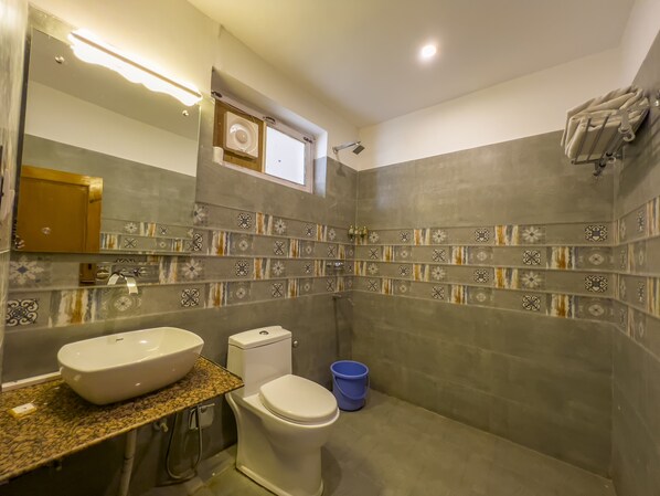 Une salle de bain avec un lavabo, des toilettes et une douche.