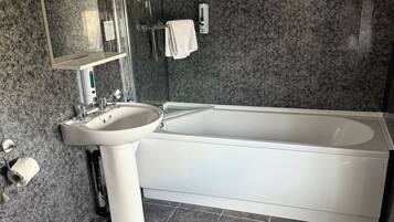 A modern bathroom with a bathtub, a sink, and a toilet.