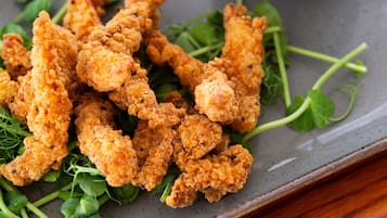Un plato de pollo frito con vegetales de hoja verde.