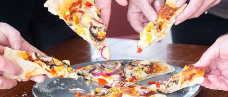 Um grupo de pessoas segurando fatias de pizza.