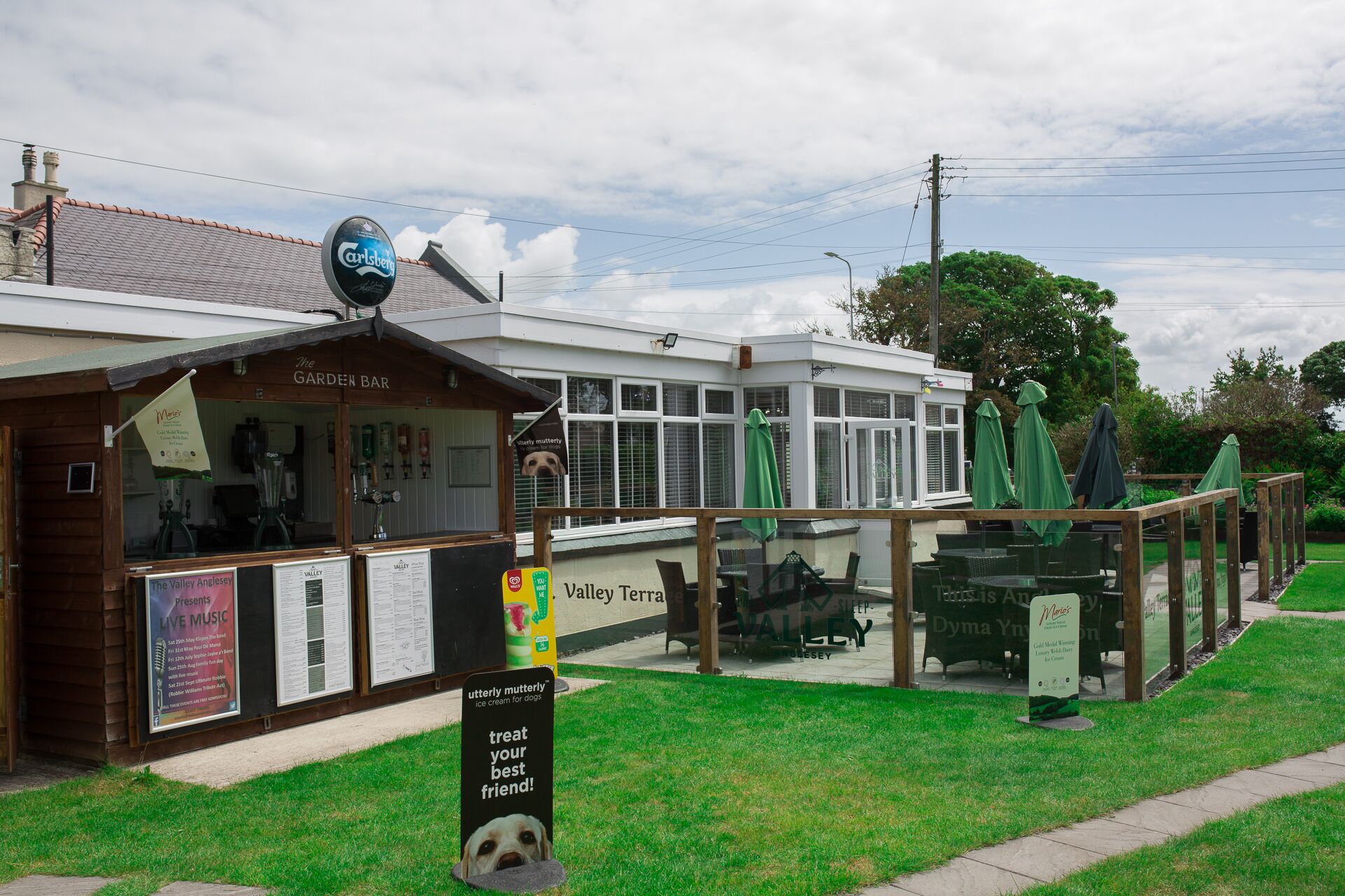 A garden bar with outdoor seating and a sign for 'Valley Terra'.