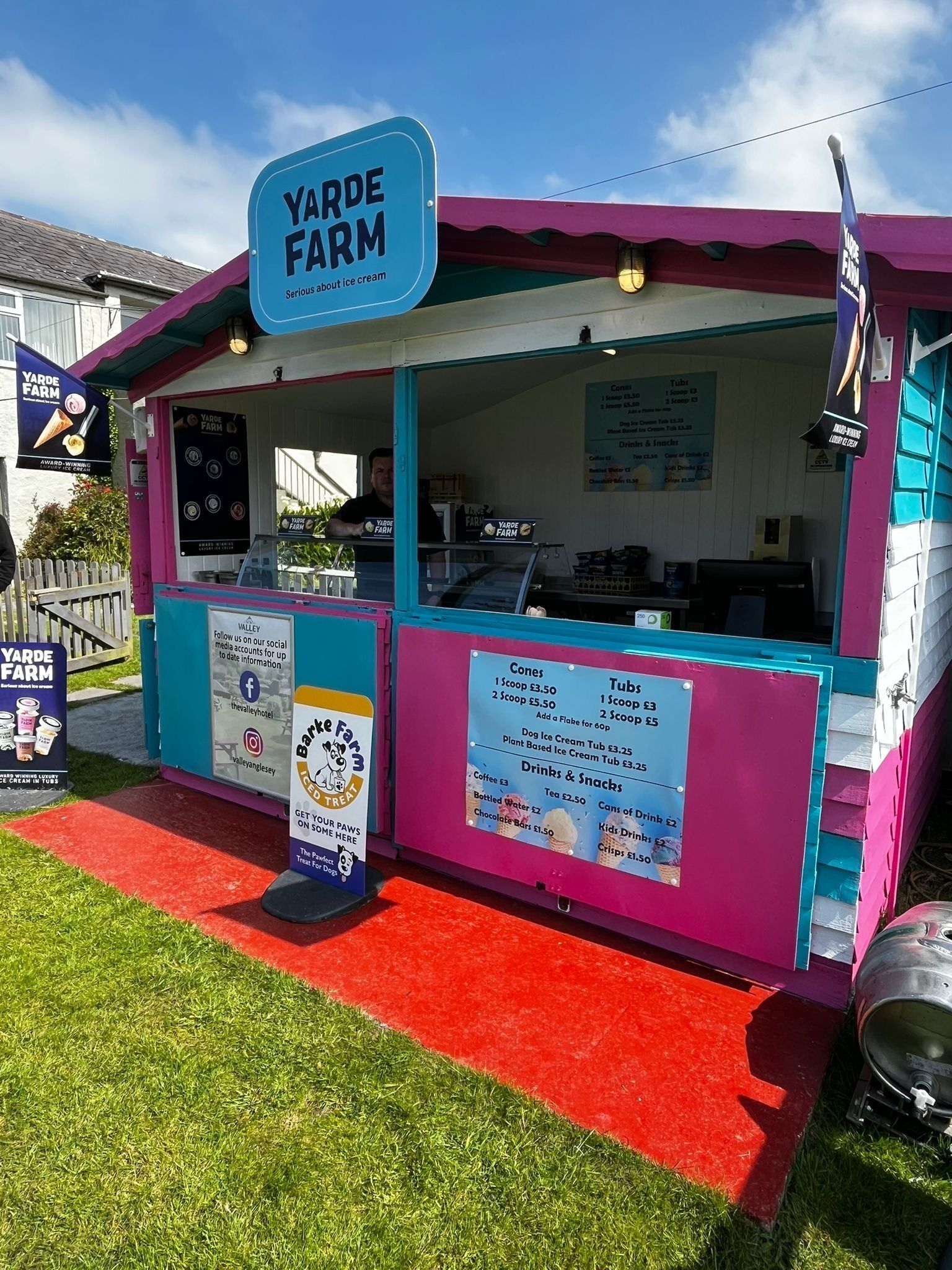 A colorful ice cream stand named 'Yarde Farm' with a menu board and social media information.
