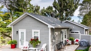 Une maison à deux étages dotée d’un patio couvert, d’une petite terrasse et d’une pelouse.