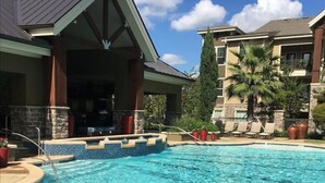Una piscina con un letrero de no buceo, sillas de descanso y una terraza de piedra.