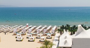 A beachside hotel with rows of sun loungers and umbrellas, a pool area, and a view of the sea. - Europe Hotel & Casino (Sunny Beach)