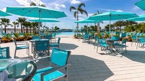 A poolside area with turquoise umbrellas, lounge chairs, and a clear view of the pool.