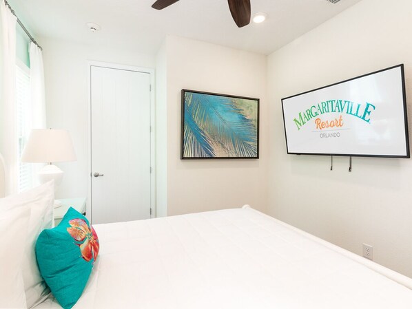 Un dormitorio con cama, una puerta, un cuadro enmarcado y un cartel para Marigotaville Resort.