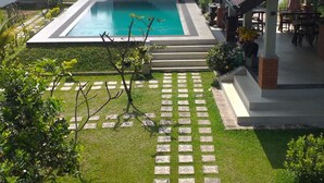 A house with a swimming pool, a covered patio, and a well-maintained lawn. - Green wood villa (Negombo)