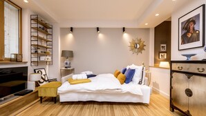 A modern bedroom with a large bed, bedside tables, a wardrobe, and built-in shelving. - Golden Apartament by Your Freedom (Warsaw)