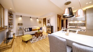 A modern living room with a sofa, coffee table, and a dining area with a white table and chairs. - Golden Apartament by Your Freedom (Warsaw)