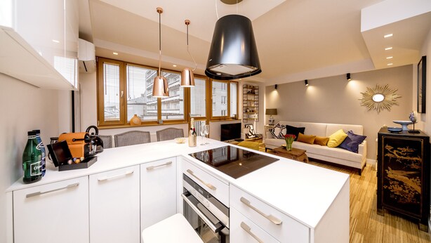 A modern kitchen with white cabinetry, a central island, and pendant lighting. - Golden Apartament by Your Freedom (Warsaw)