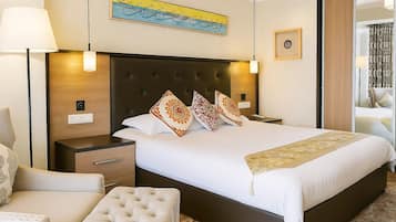 Una habitación de hotel con una cama grande, una mesita de noche, una silla y una pequeña mesa.