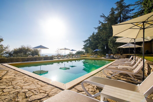 Una piscina al aire libre de temporada, sombrillas, tumbonas