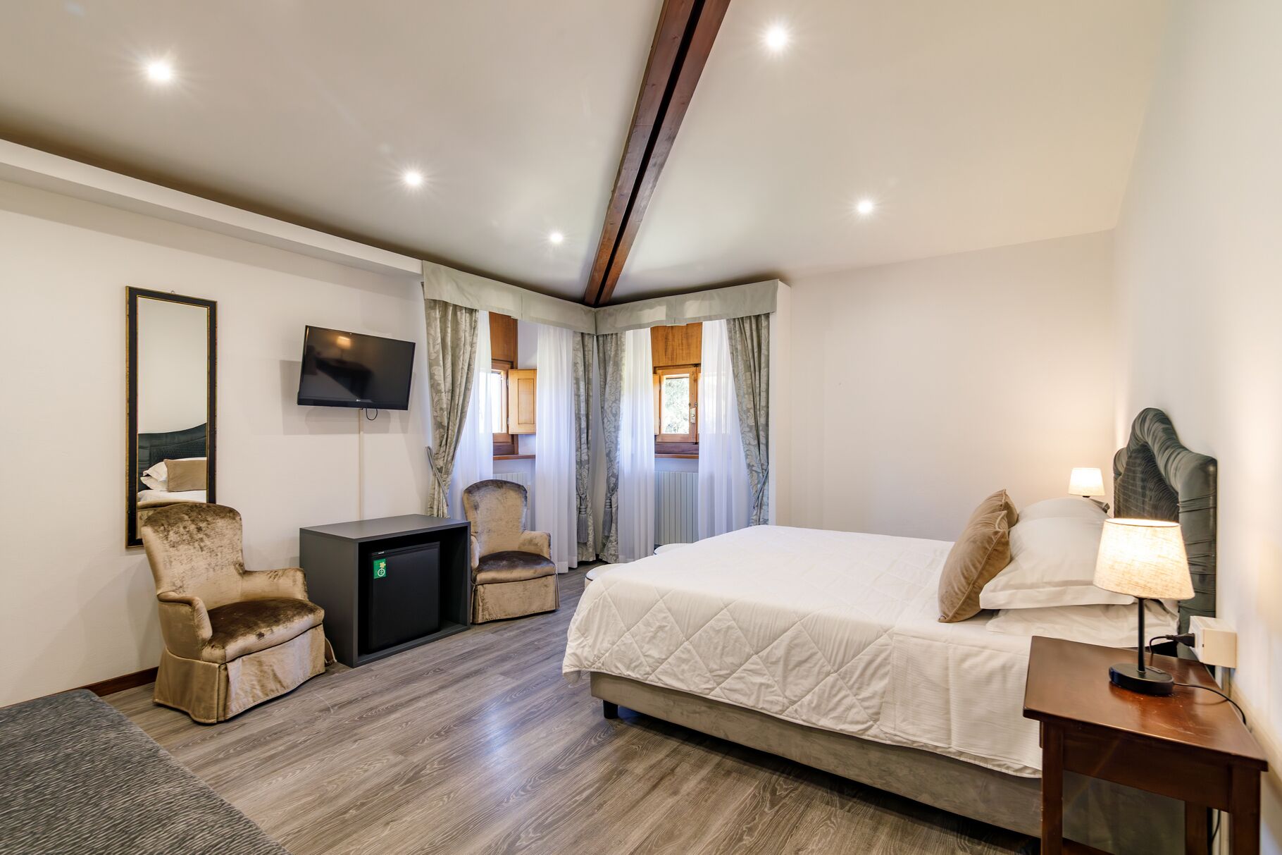 Een hotelkamer met een bed, een bureau, een televisie en een stoel.