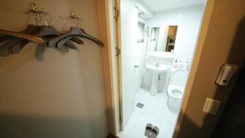 A bathroom with a toilet, sink, and shower.