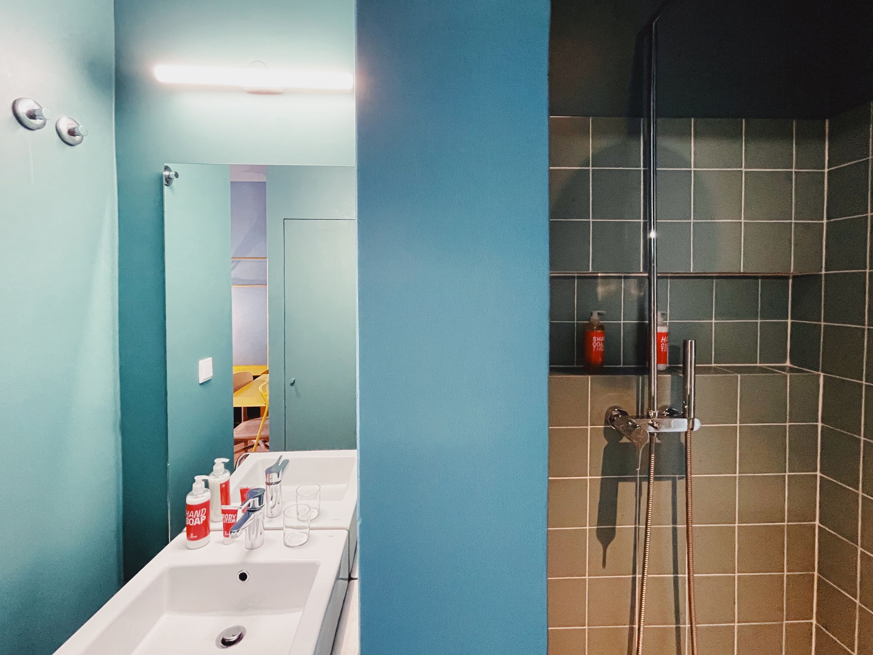 Une salle de bain avec un lavabo, un miroir et une douche.