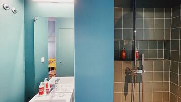 Une salle de bain avec un lavabo, un miroir et une douche.