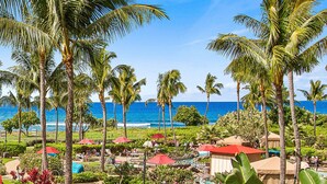 Ein Resort mit Palmen, einem Poolbereich und Blick aufs Meer.