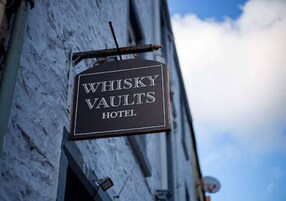 A sign for the Whisky Vaults Hotel.