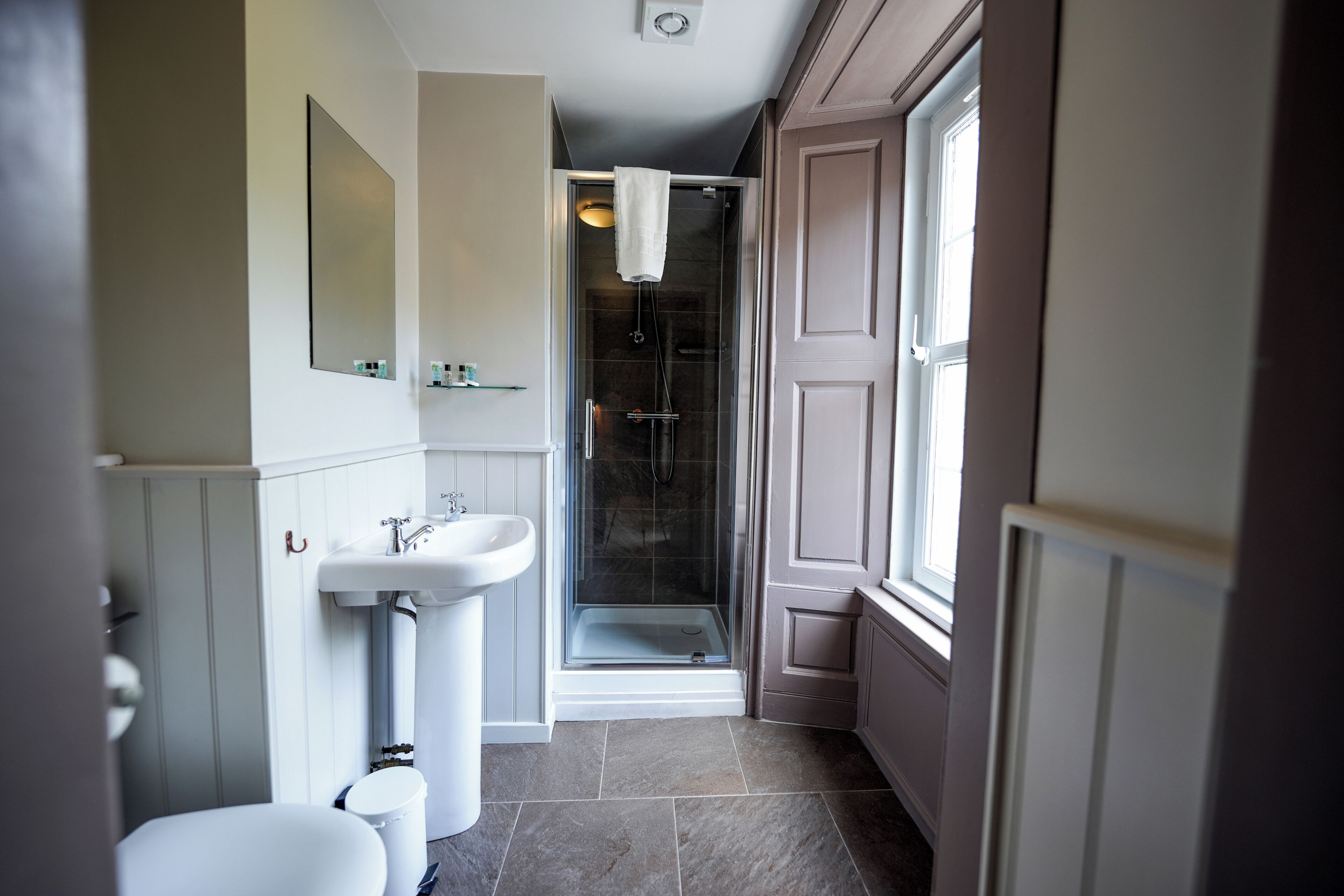 Une salle de bain avec une douche, un lavabo et des toilettes.