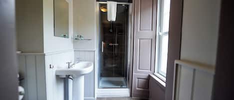 Une salle de bain avec une douche, un lavabo et des toilettes.