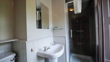 A bathroom with a sink, mirror, and shower.