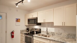 A modern kitchen with white cabinets, a stainless steel microwave, an oven, and a sink. - Quiet & Private S. Kihei 1BR Guest Suite - 10 minute walk to Kamaole Beach II (Kihei)