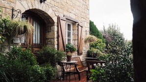 A stone building with a tiled patio, wooden furniture, and potted plants. - Casa Lavanda Butik Hotel (Sile)