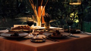 A table set for dinner with candles, glasses, and dishes, overlooking a forested area. - Casa Lavanda Butik Hotel (Sile)