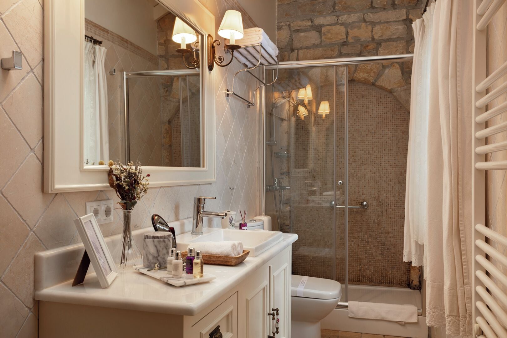 Un baño con ducha, lavabo, inodoro y espejo.