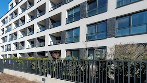 A multi-story building with balconies, a gated entrance, and a clear sky. - P&O Okecie 4 (Warsaw)