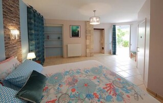 Quarto com cama, mesa de cabeceira, abajur, cômoda e janela.