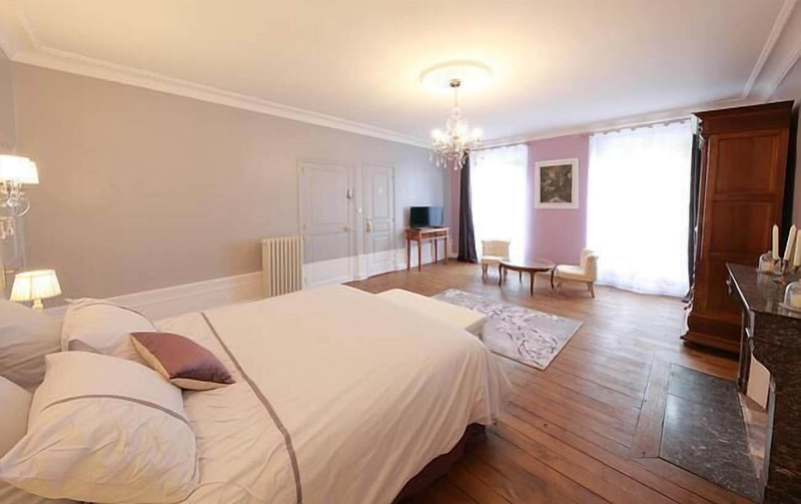 Une chambre à coucher avec un grand lit, un bureau, une chaise et un téléviseur.