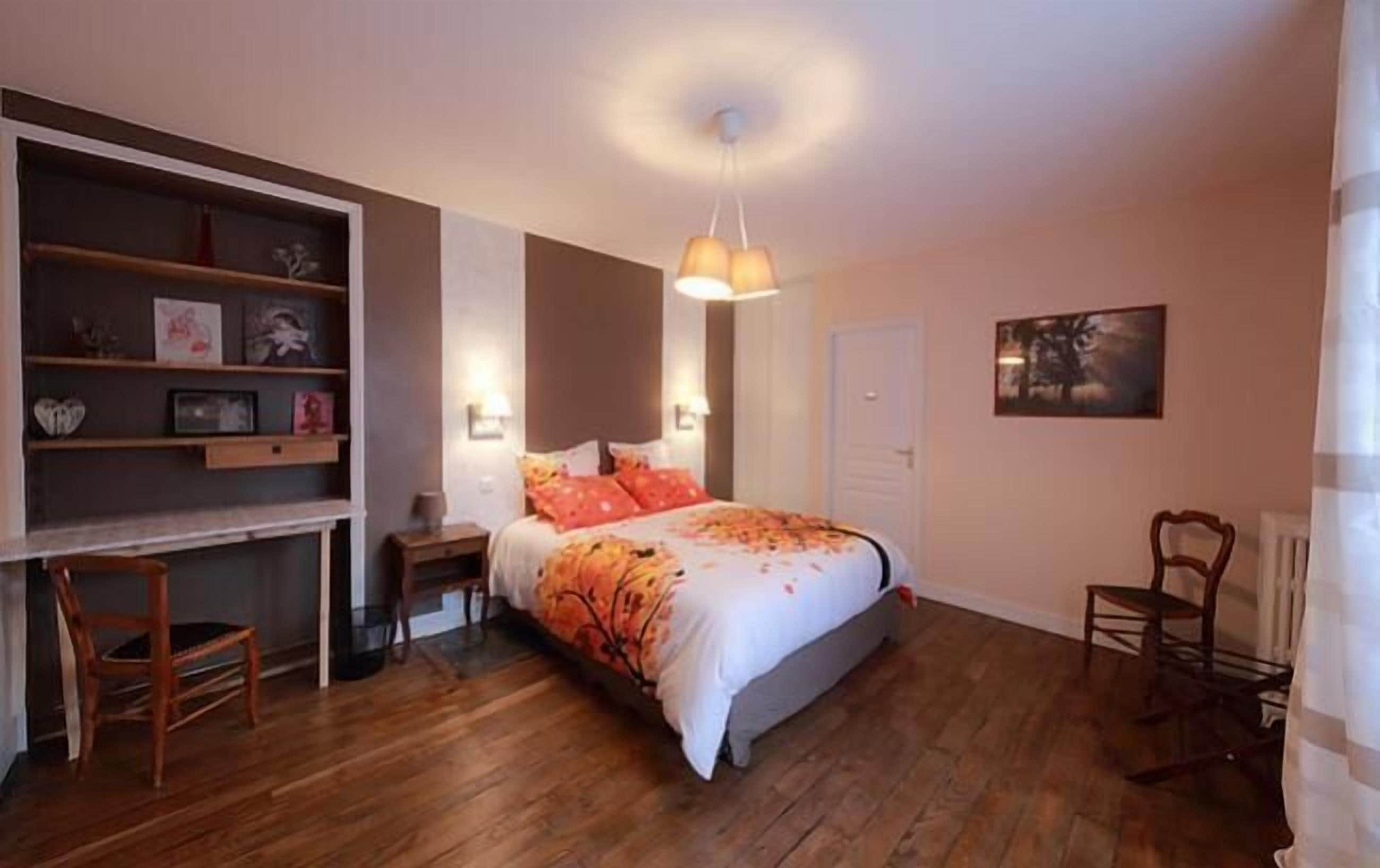 Ein Schlafzimmer mit Bett, Schreibtisch und Stuhl.