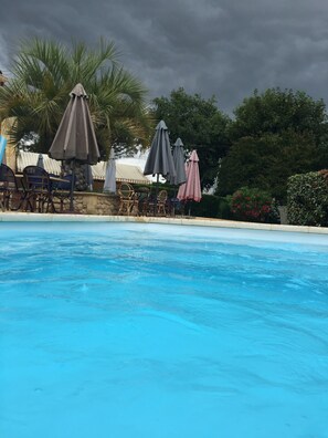 A swimming pool with lounge chairs and umbrellas. - Le Melchior (Sainte-Terre)