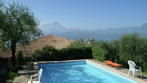 A swimming pool with a view of mountains in the background. - Villa Patrizia (Torri del Benaco)