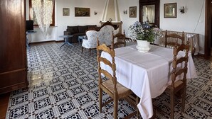 A dining area with a patterned floor, a chandelier, and a table set for four. - Villa Patrizia (Torri del Benaco)